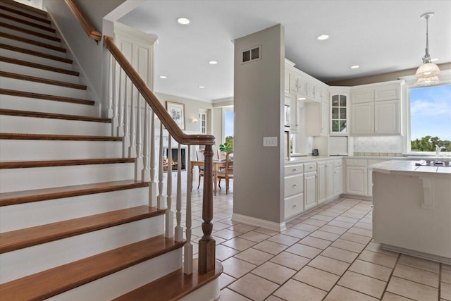 N84W36411 Riverwood Ln, Oconomowoc, WI 53066 - kitchen with light tile patterned floors, decorative backsplash, pendant lighting, and white cabinets