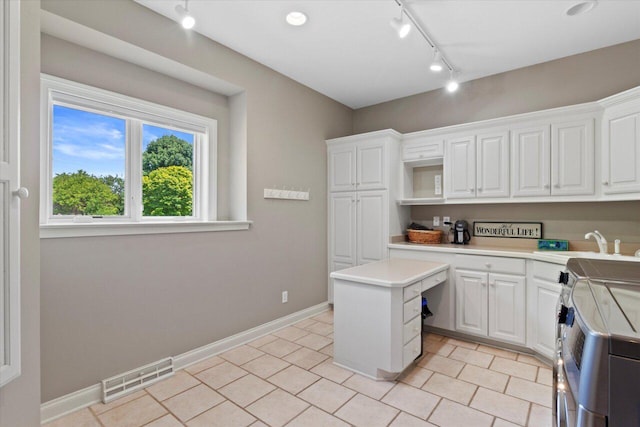 N84W36411 Riverwood Ln, Oconomowoc, WI 53066 - kitchen with sink, stainless steel electric stove, white cabinetry, and a kitchen island