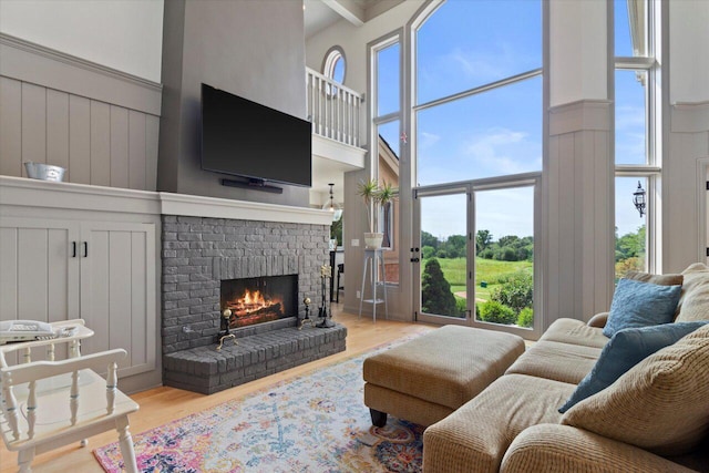 N84W36411 Riverwood Ln, Oconomowoc, WI 53066 - living room with hardwood / wood-style flooring, a fireplace, and a high ceiling