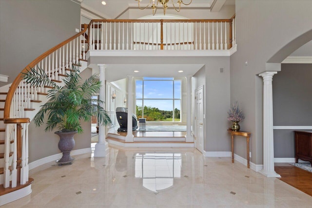 N84W36411 Riverwood Ln, Oconomowoc, WI 53066 - foyer with a towering ceiling, crown molding, ornate columns, and a chandelier