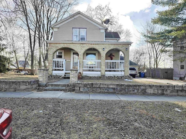 view of front facade featuring a porch and fence