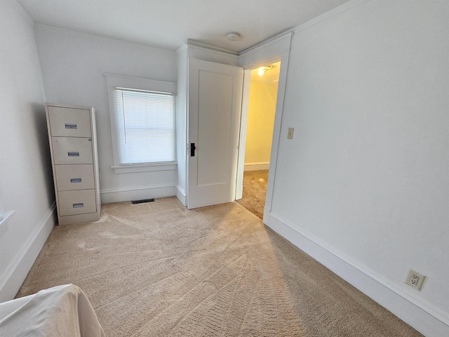 unfurnished bedroom featuring light carpet, visible vents, and baseboards