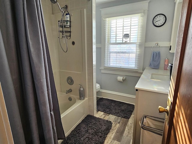 full bath with baseboards, toilet, wood finished floors, shower / bath combination with curtain, and vanity