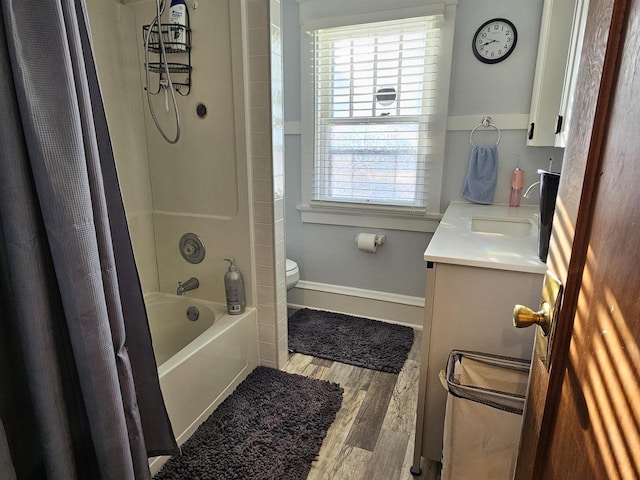 bathroom featuring a healthy amount of sunlight, toilet, wood finished floors, and vanity