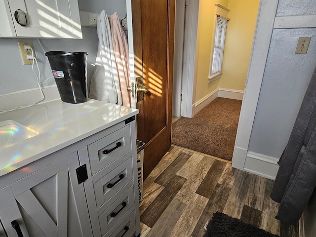 kitchen featuring dark wood-style floors, baseboards, and light countertops