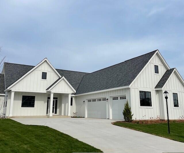 modern inspired farmhouse featuring a garage and a front lawn