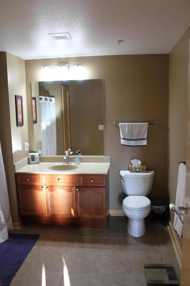 bathroom with toilet, tile patterned flooring, and vanity