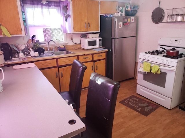 kitchen featuring light wood-type flooring, sink, and white appliances