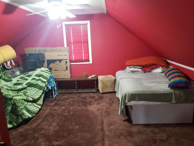 bedroom with ceiling fan, vaulted ceiling, and dark colored carpet