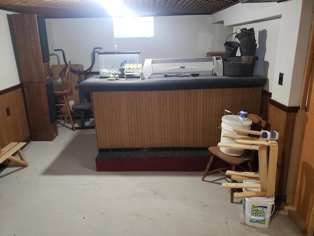 home office featuring bar area, wooden walls, and concrete floors