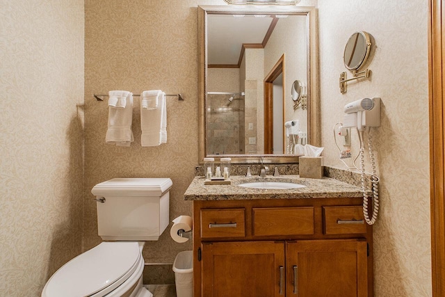 bathroom with toilet, vanity, and crown molding