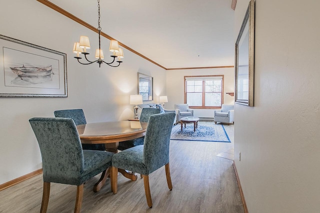 dining area with an inviting chandelier, crown molding, and hardwood / wood-style floors