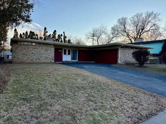 ranch-style home featuring a garage and a front lawn