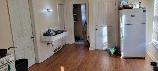 kitchen with white refrigerator and dark hardwood / wood-style flooring