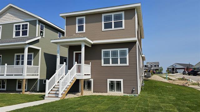 exterior space with cooling unit and a front lawn