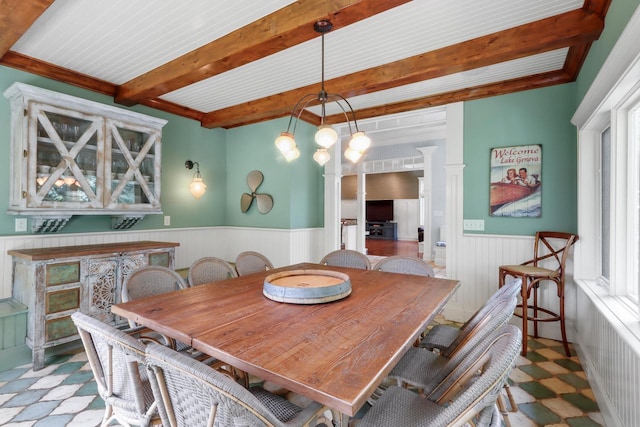 dining area featuring ornate columns and beam ceiling