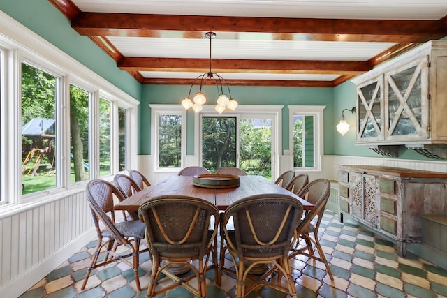 dining area with beam ceiling and a notable chandelier