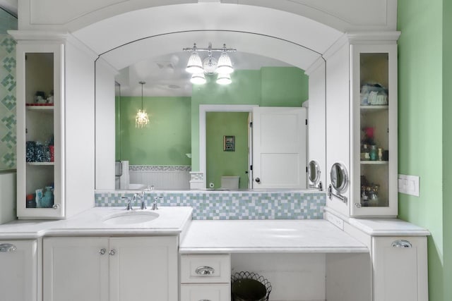 bathroom featuring vanity and backsplash