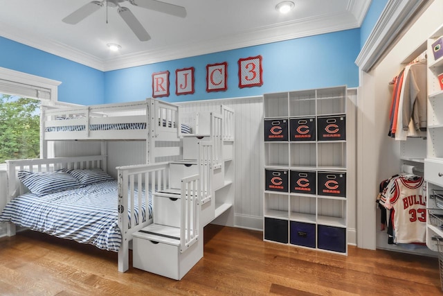 bedroom with ceiling fan, hardwood / wood-style floors, and ornamental molding