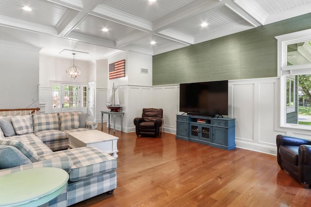 living room with ornamental molding, a chandelier, light wood-type flooring, beam ceiling, and coffered ceiling