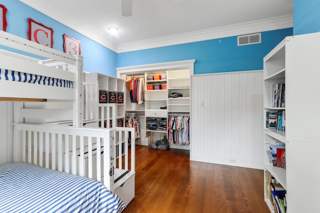 bedroom featuring dark wood-type flooring, a closet, and ornamental molding