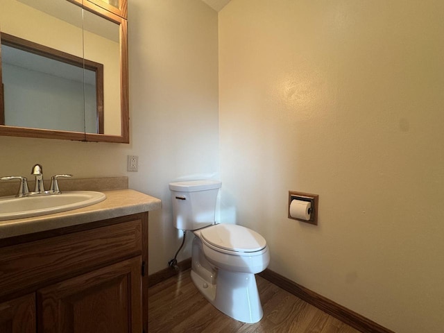 bathroom with toilet, hardwood / wood-style flooring, and vanity