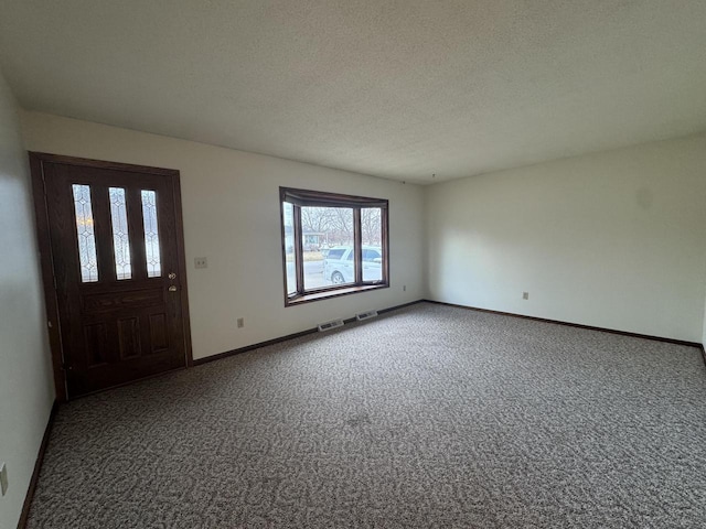 entrance foyer featuring carpet floors and a textured ceiling