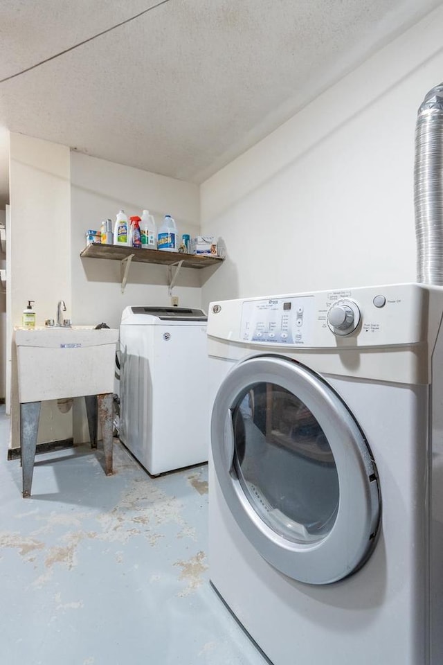 laundry room with washing machine and dryer and a textured ceiling