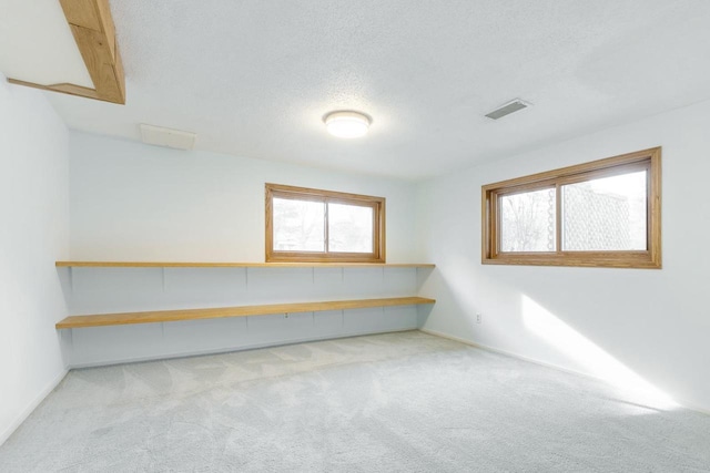 carpeted empty room featuring a textured ceiling