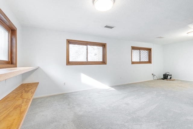 carpeted spare room featuring a textured ceiling