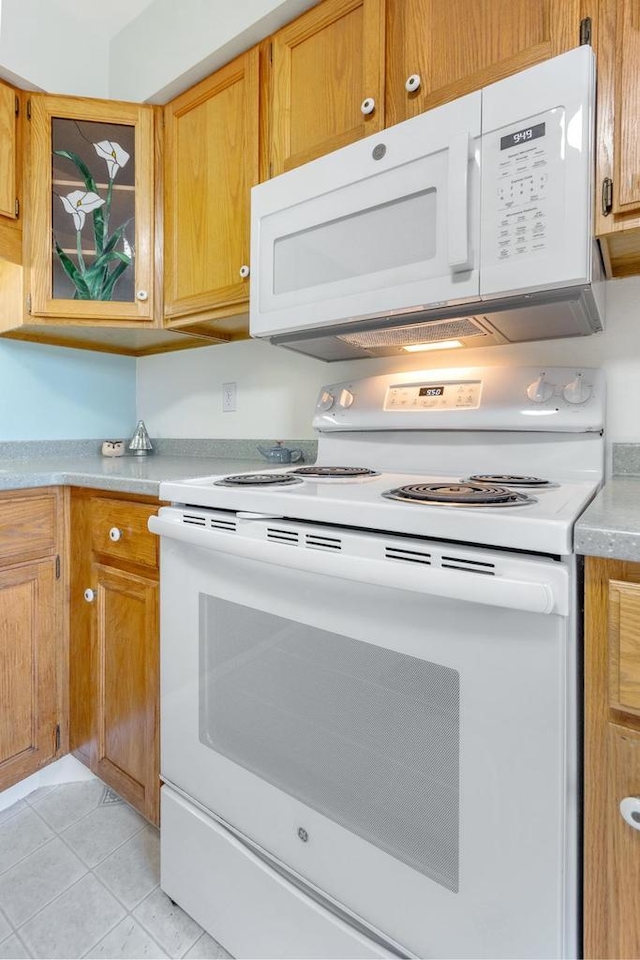 kitchen with white appliances and light tile patterned floors