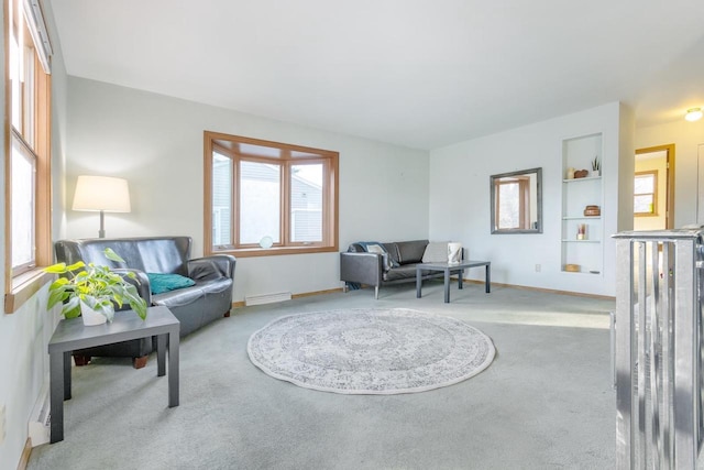 carpeted living room with built in shelves and a baseboard radiator