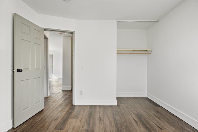 unfurnished bedroom with a closet and dark wood-type flooring