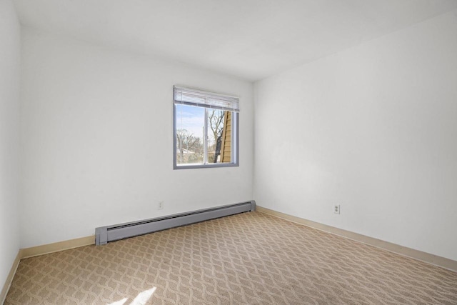 spare room featuring light colored carpet and a baseboard radiator