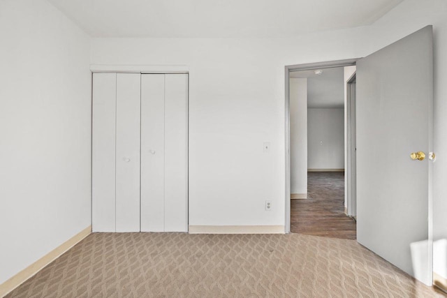 unfurnished bedroom featuring a closet and light colored carpet