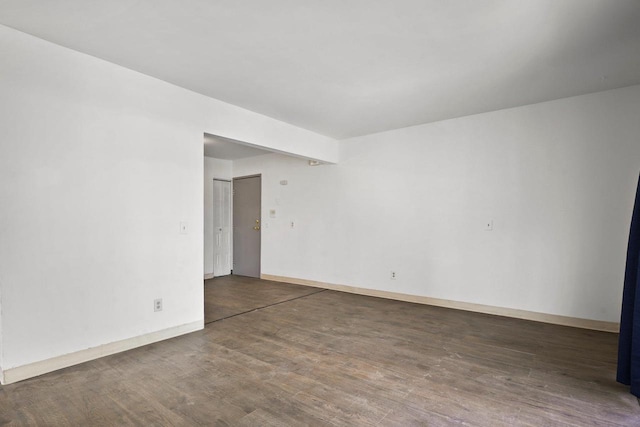 empty room with dark hardwood / wood-style flooring