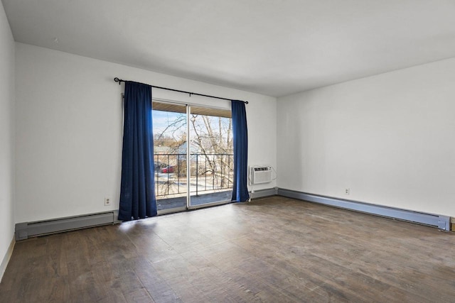 spare room featuring a baseboard heating unit, a wall mounted AC, and hardwood / wood-style flooring