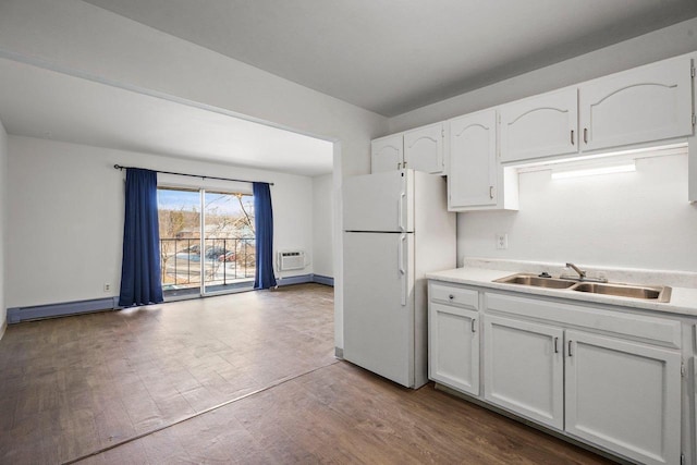 kitchen featuring a baseboard radiator, white cabinets, wood-type flooring, white fridge, and sink