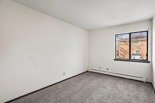 empty room featuring carpet floors and a baseboard heating unit