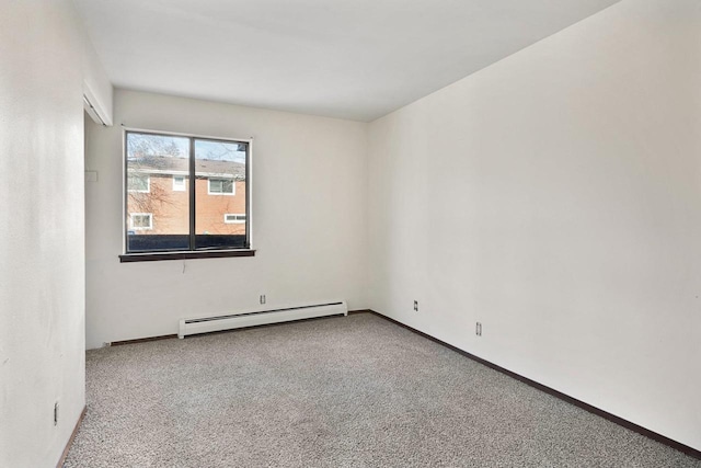 empty room featuring a baseboard heating unit and carpet floors