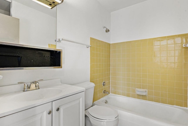 full bathroom featuring toilet, tiled shower / bath, and vanity