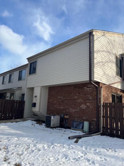 snow covered property featuring central air condition unit