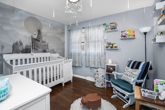 bedroom featuring dark hardwood / wood-style floors and a nursery area