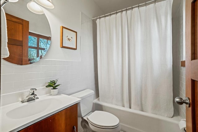 full bathroom with shower / bath combination with curtain, vanity, toilet, and tile walls