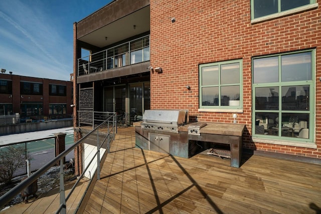 wooden deck featuring exterior kitchen and a grill