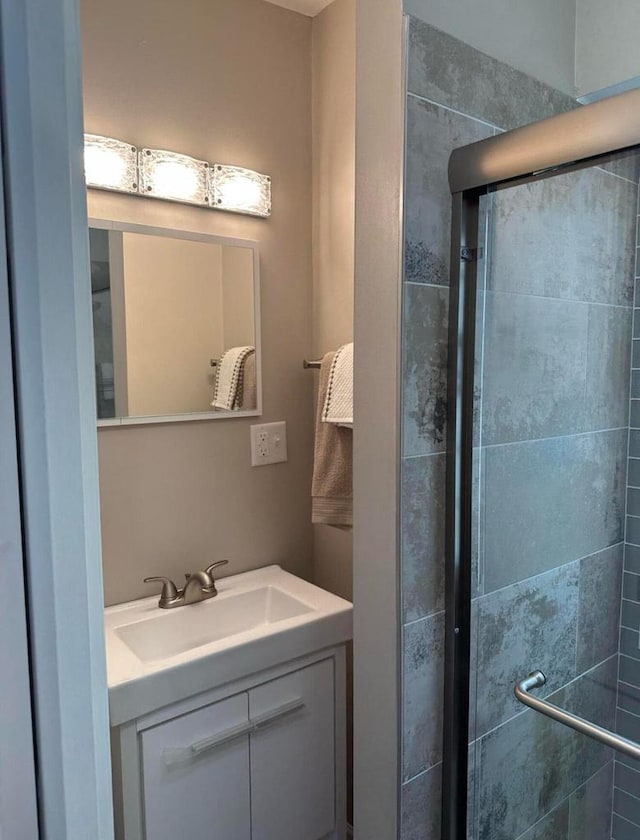 bathroom with walk in shower and vanity