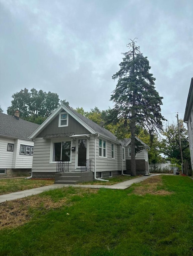 bungalow-style home featuring a front lawn