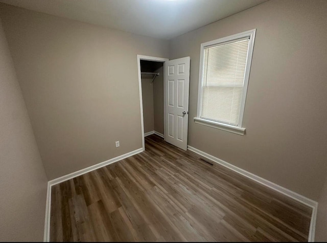 unfurnished bedroom with a closet and hardwood / wood-style floors