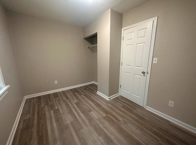 unfurnished bedroom featuring a closet and dark hardwood / wood-style flooring