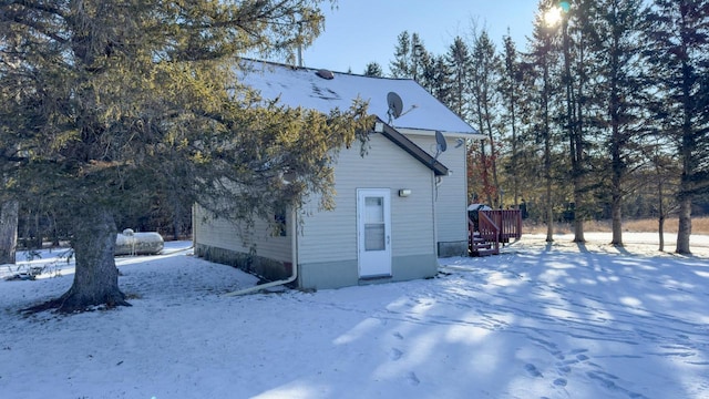 view of snowy exterior with a wooden deck